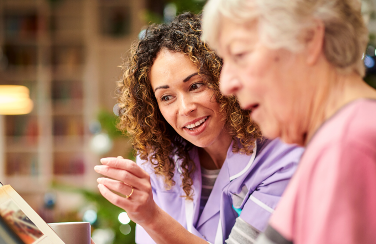 How To Get Into A Care Career - Carer reading to elderly women