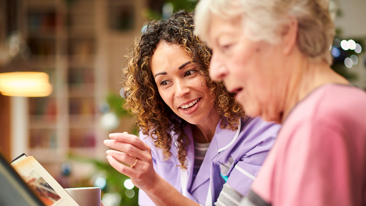 How To Get Into A Care Career - Carer reading to elderly women